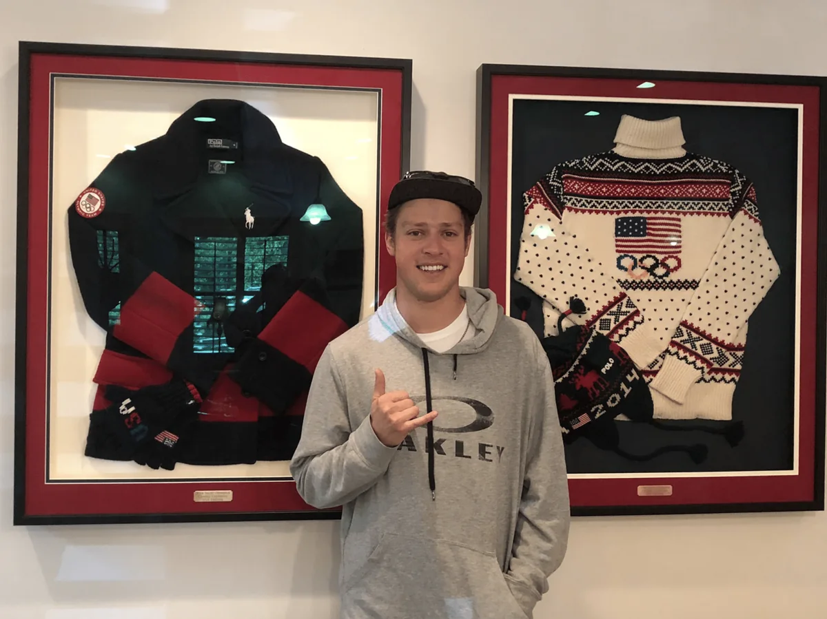 Brad Wilson with Dr. Peterson in front of framed Team USA memorabilia