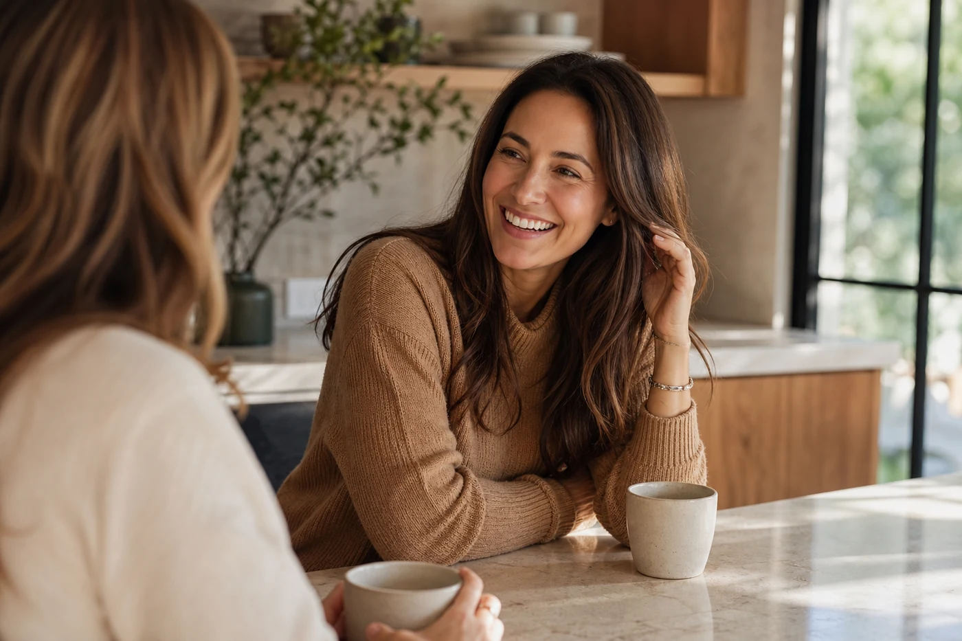 Patient laughing naturally during a refined coffee conversation